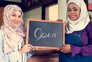 Caregiver holding older woman's hand outdoors