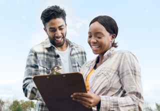 Caregiver holding older woman's hand outdoors