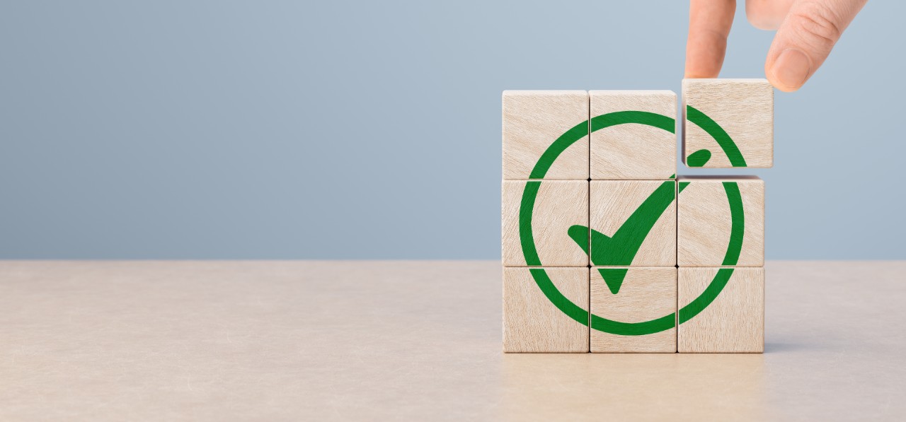 Regulatory and compliance. Goals achievement and business success. Task completion. Ethical corporate. Quality and ISO symbol. Wooden cube with green checkmark icon.
