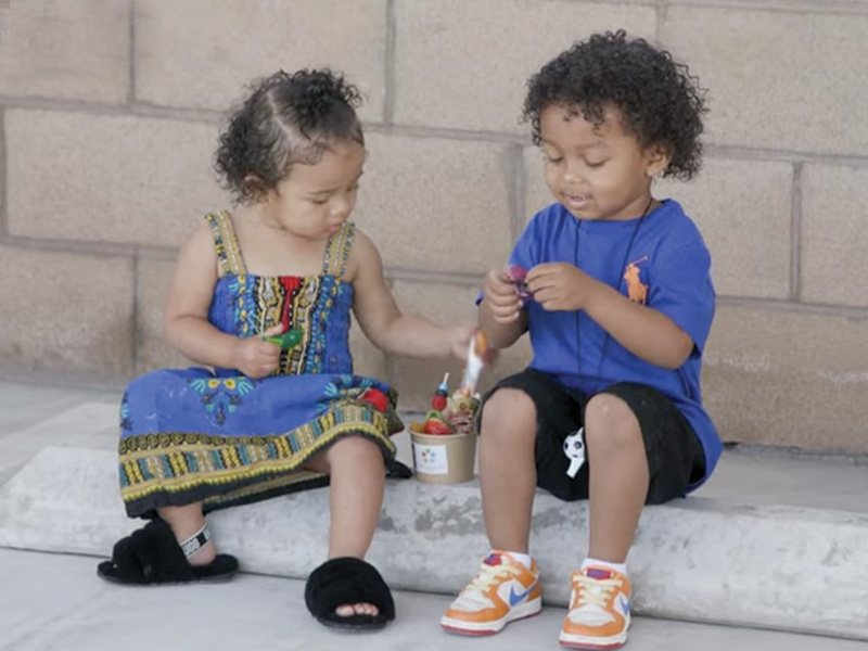 Kids sitting on sidewalk