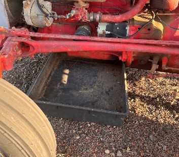 A drip pan underneath an older tractor