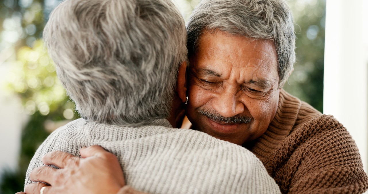 Two older adults hugging