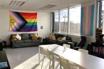 Sunlit room at North Inland YMCA Drop-in center with couch, table, and LGTBQIA+ flag