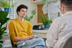 Teen boy meeting with counselor in an office