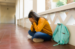 Student sitting down with face in hands