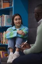 Young female student talking to counselor