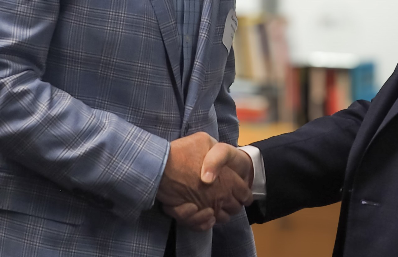 Two people shaking hands in a business setting