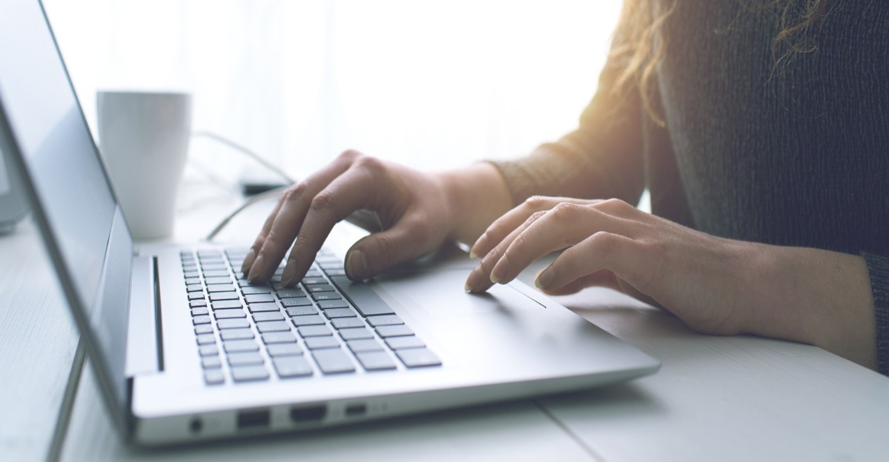 A person typing on a laptop computer