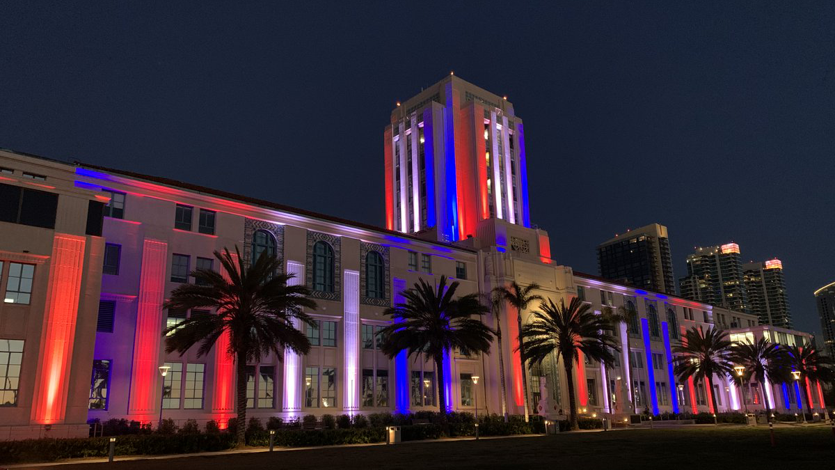 San Diego County administration center at lit up at night with red and blue lights