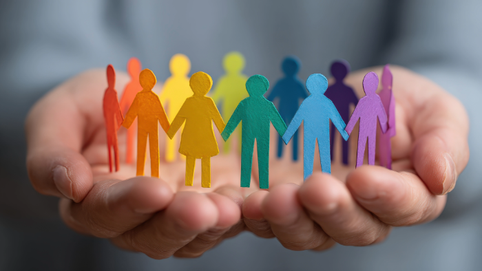 cupped hands holding multicolored paper people