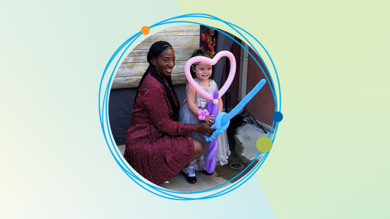A woman and a young girl in a dress holding a heart shaped balloon
