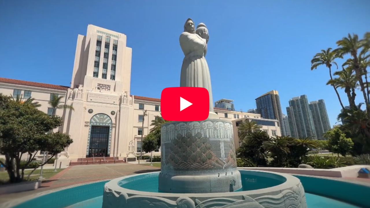 West side of the county administration center with building tower in background and "Guardian of Water" granite sculpture in foreground
