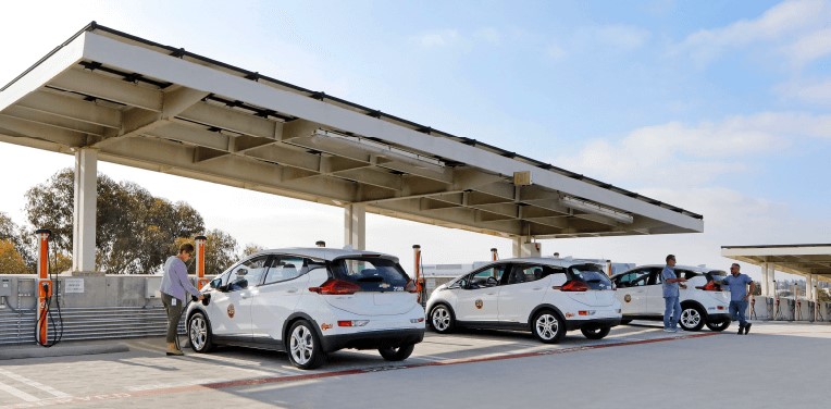 Electric vehicles charging under solar panels