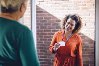 Photo of a social services worker at the door of an older adult 