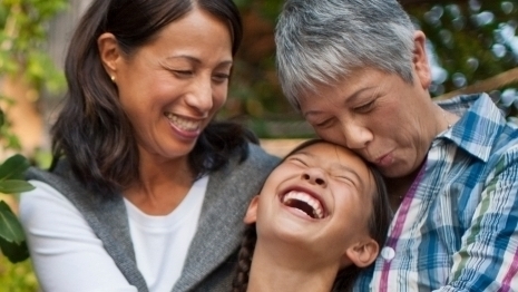 grandmother, daughter, and grandaughter hugging and sittig on the porch