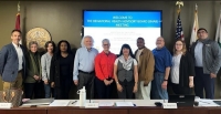 Group of people standing in front of a projector screen at a past BHAB meeting