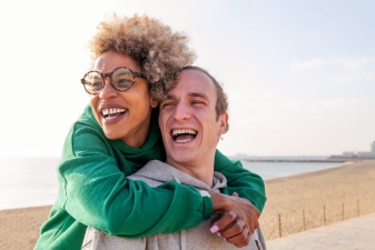 Man and woman laughing and smiling on beach
