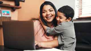 Smiling mother and son in front of a laptop