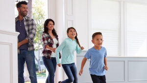 Family of four running through the doorway of a home.