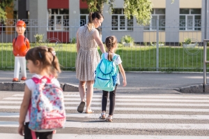 Back to school education concept with girl kids, elementary students, carrying backpacks going to class