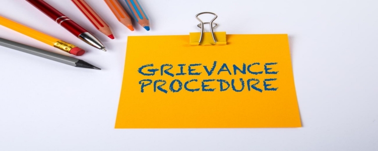 Decorative stock image of a sticky note which reads: "Grievance Procedure"