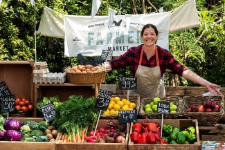 Greengrocer selling organic fresh agricultural product at farmer market