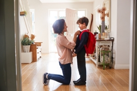 mother helping child get ready for school
