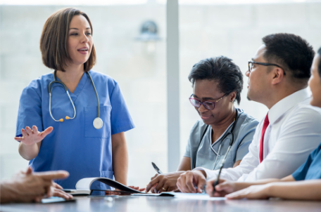 A nurse presenting to a group of professionals.