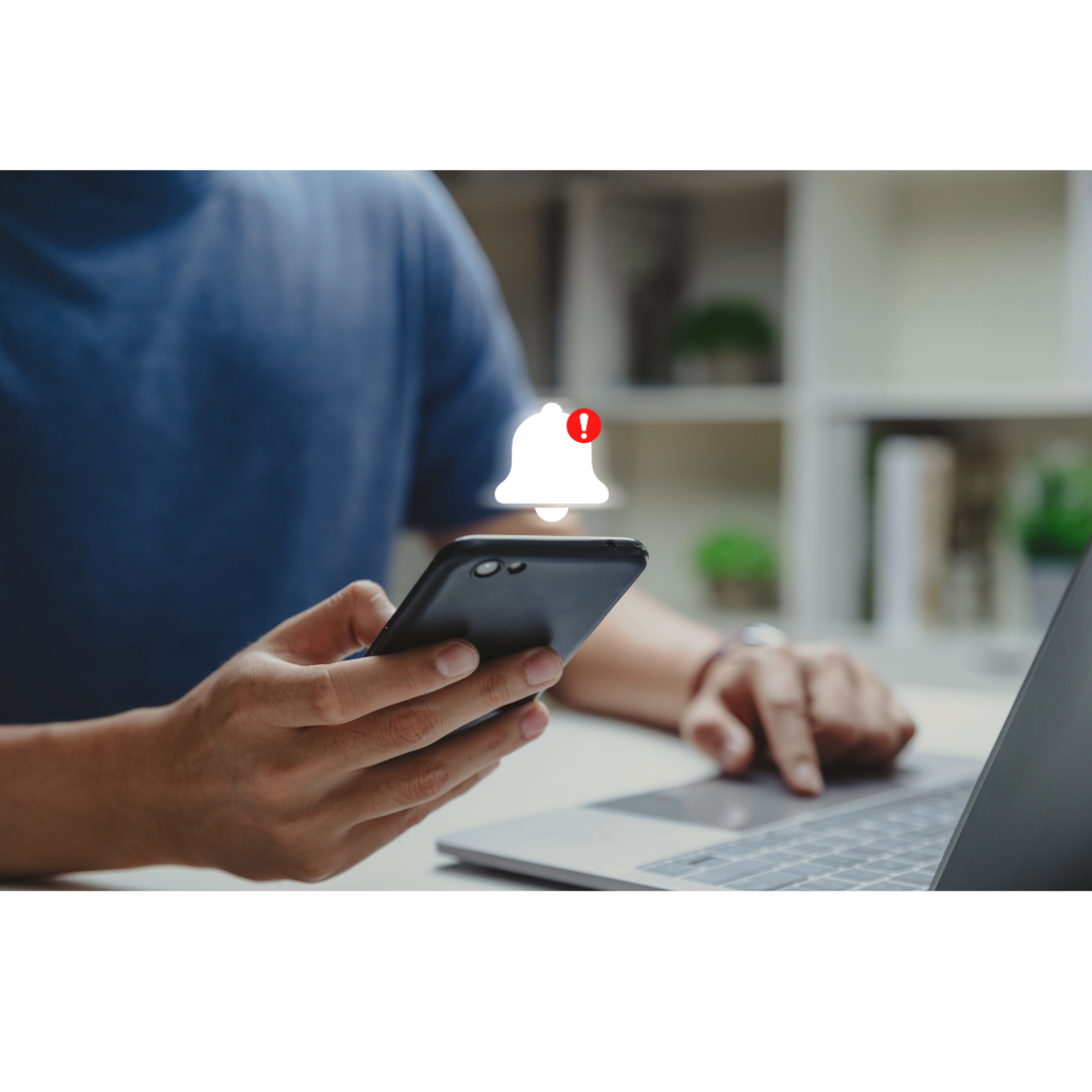 A person holding their phone with a notification alert.