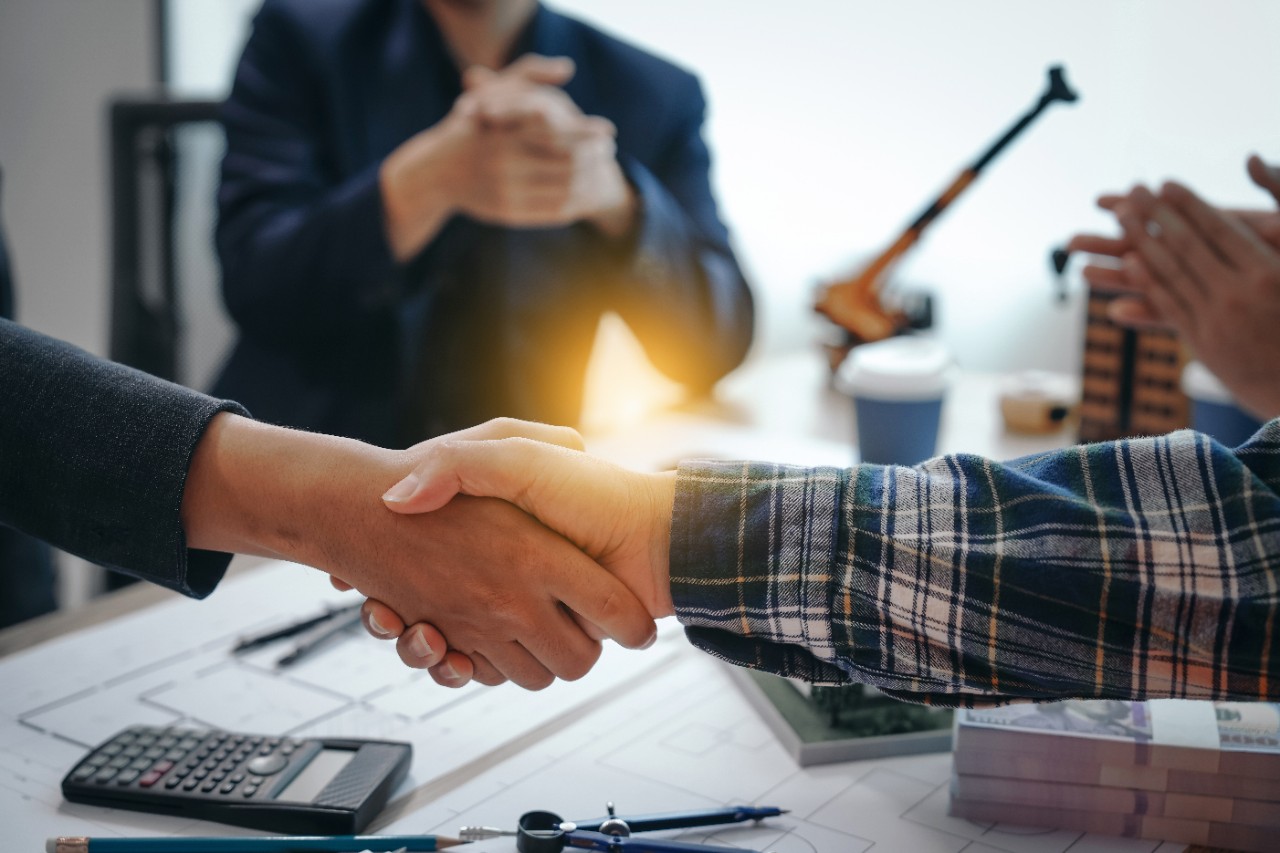 Skilled team of engineers collaborates in meetings, drafting blueprints for condos, apartments, and houses. Negotiating costs, bids, and contracts, they ensure efficient cooperation on construction