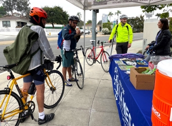 Individuals with bikes at a tabling booth