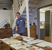 Individual pointing to materials on a table