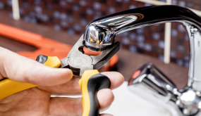 Individual installing a faucet aerator at a sink faucet