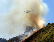 Helicopter extinguishing a fire on a hillside