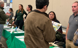 Workshop exhibitors talking with meeting participants