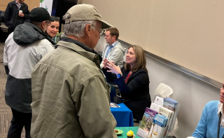 Workshop exhibitors talking with meeting participants