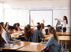 Students in a classroom raising their hands
