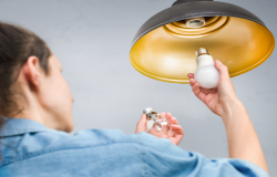 Individual changing out an LED Lightbulb